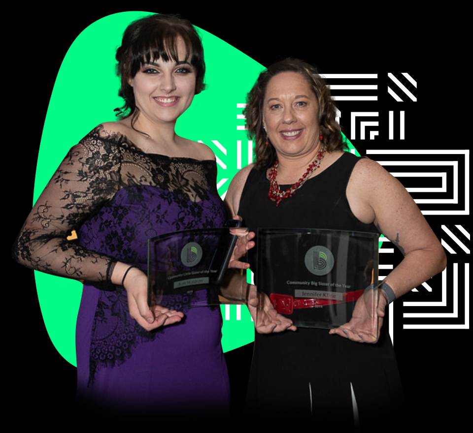 Two women holding awards