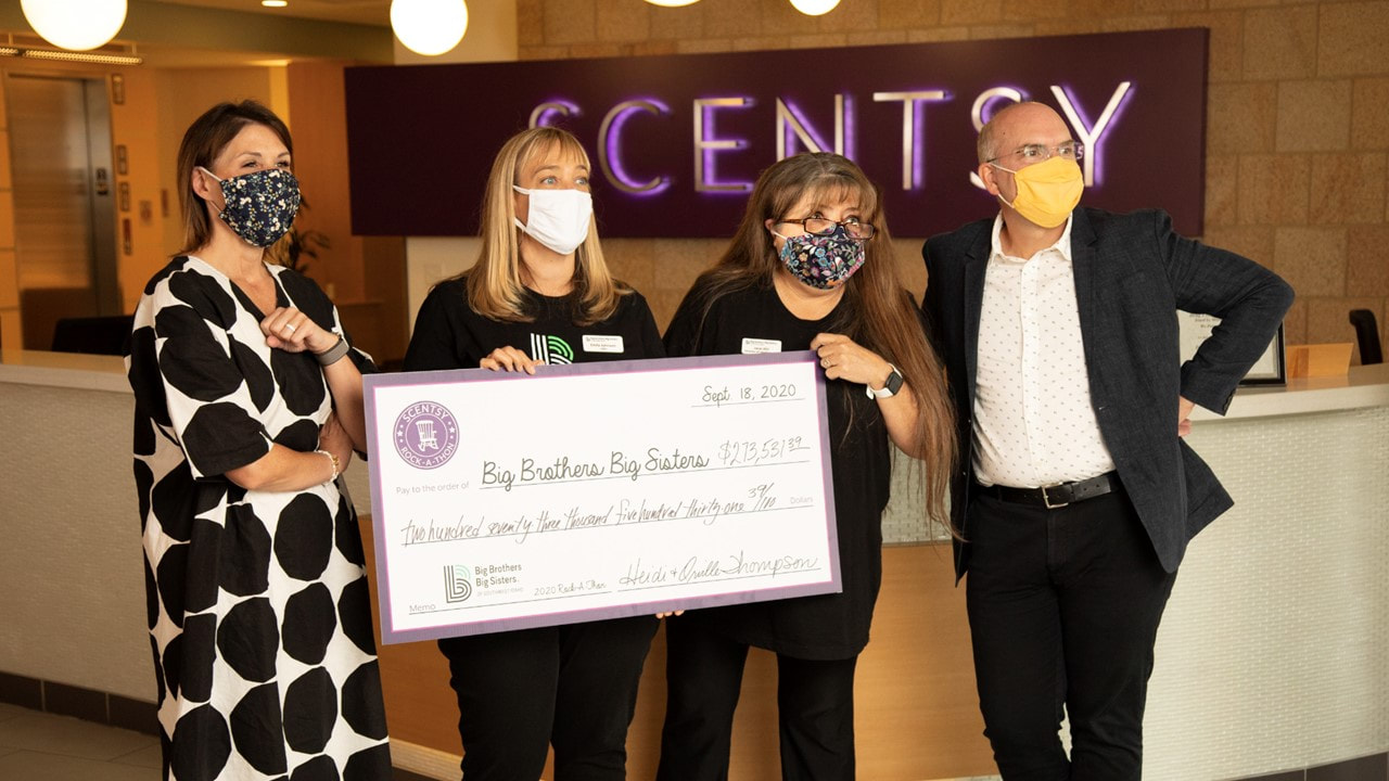 BBBS staff holding oversized check
